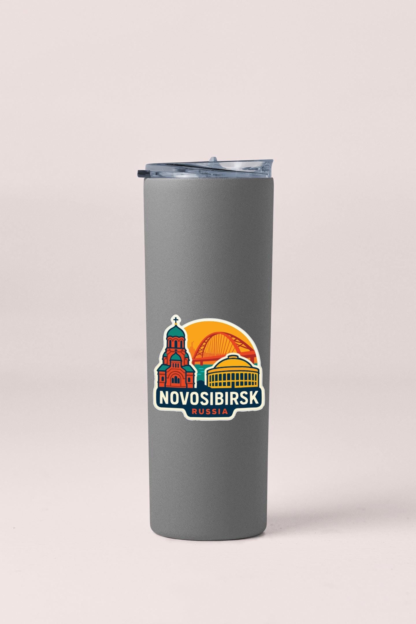 A gray insulated tumbler with a sticker depicting the Novosibirsk region of Russia.