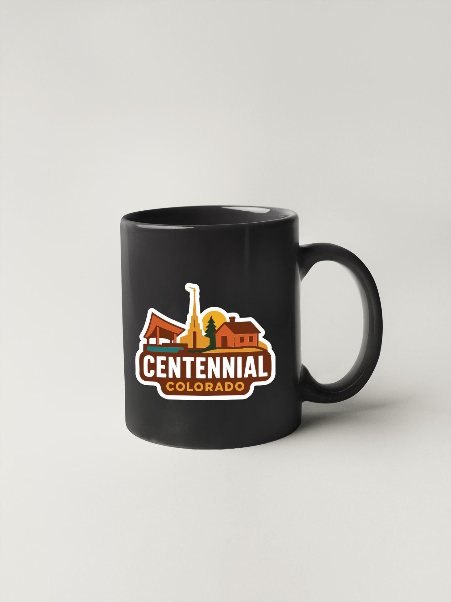 A black coffee mug with a logo that says "Centennial Colorado".
