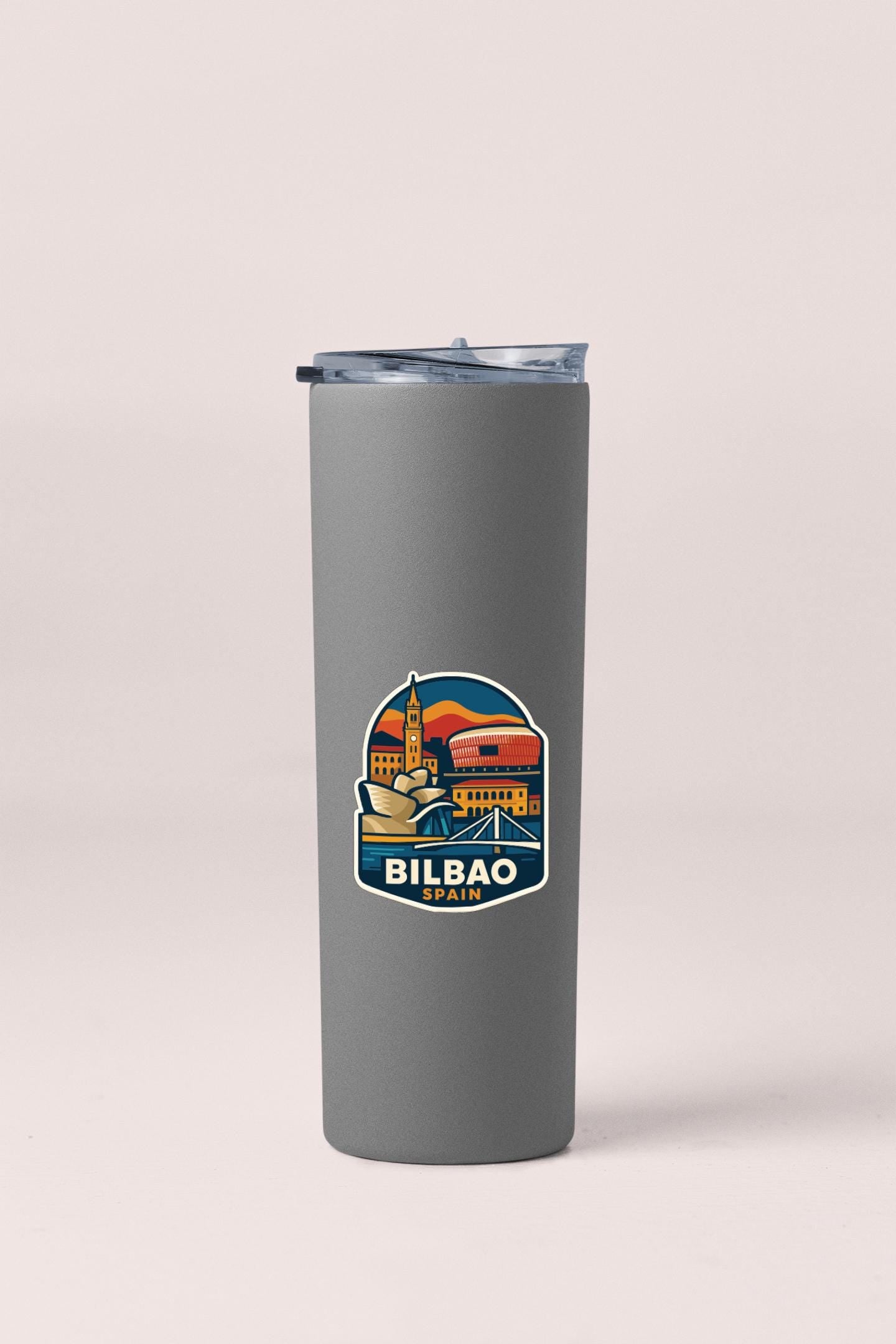 A gray insulated tumbler with a sticker depicting Bilbao, Spain.
