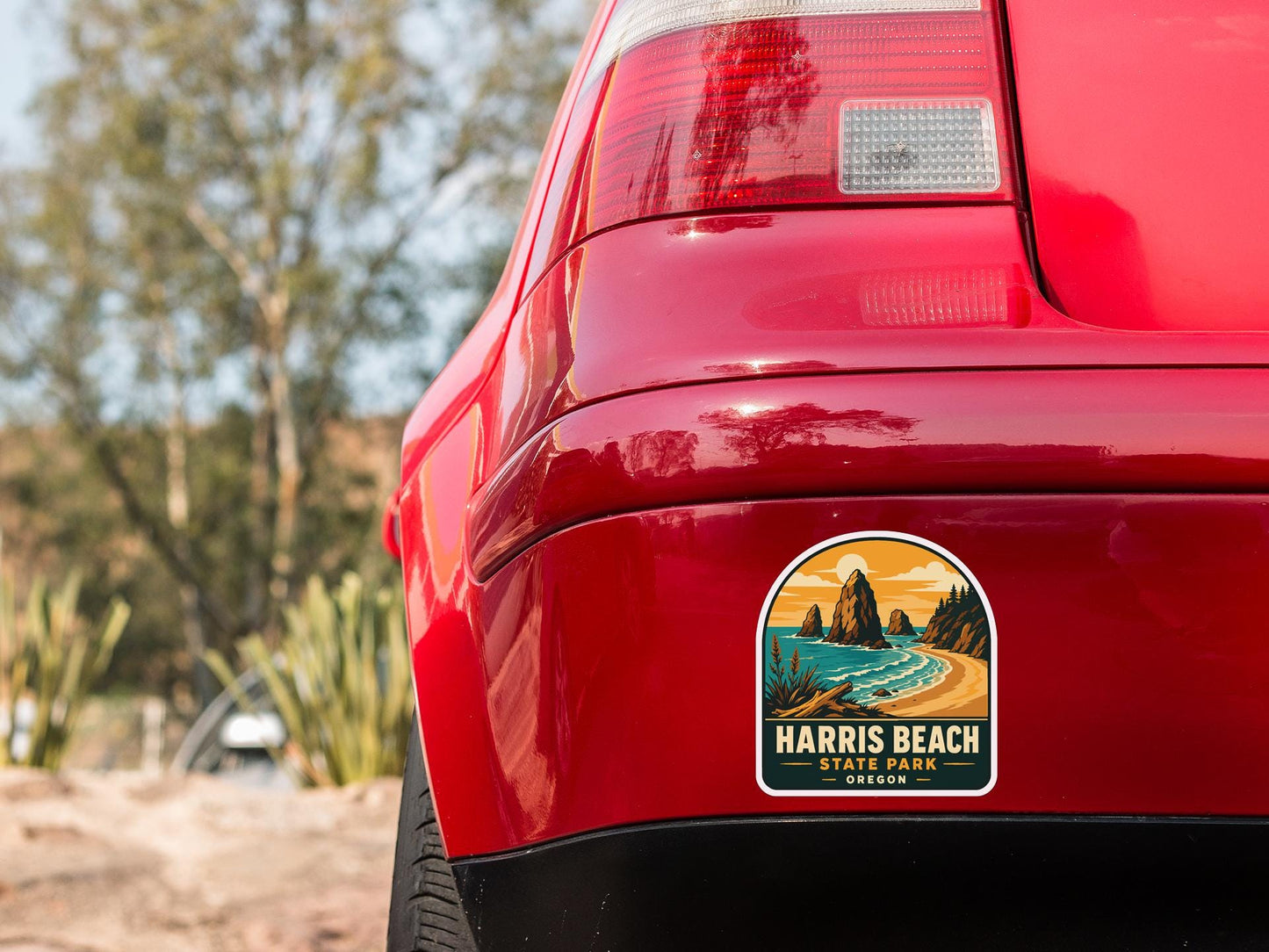the rear end of a red car with a sticker on the back window that reads "HARris Beach State Park - Oregon".
