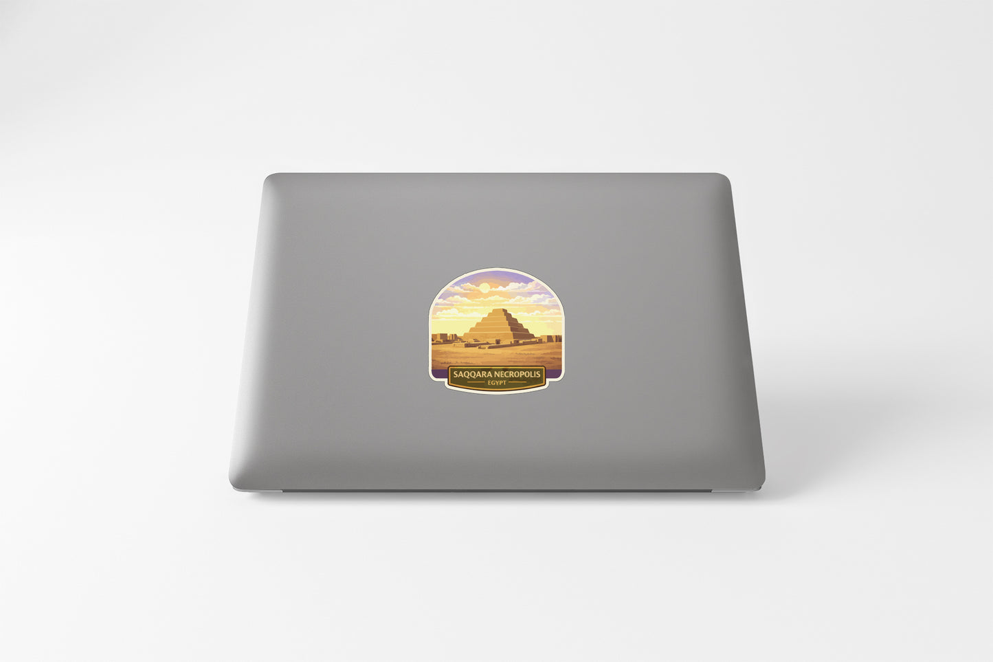 a sticker with an illustration of a pyramid and a sunset in the background.