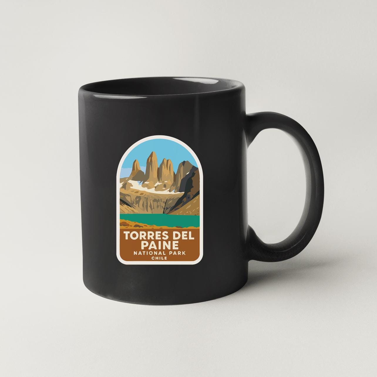 A black coffee mug with a label that says "TORRES DEL PAINE NATIONAL PARK CHILE".