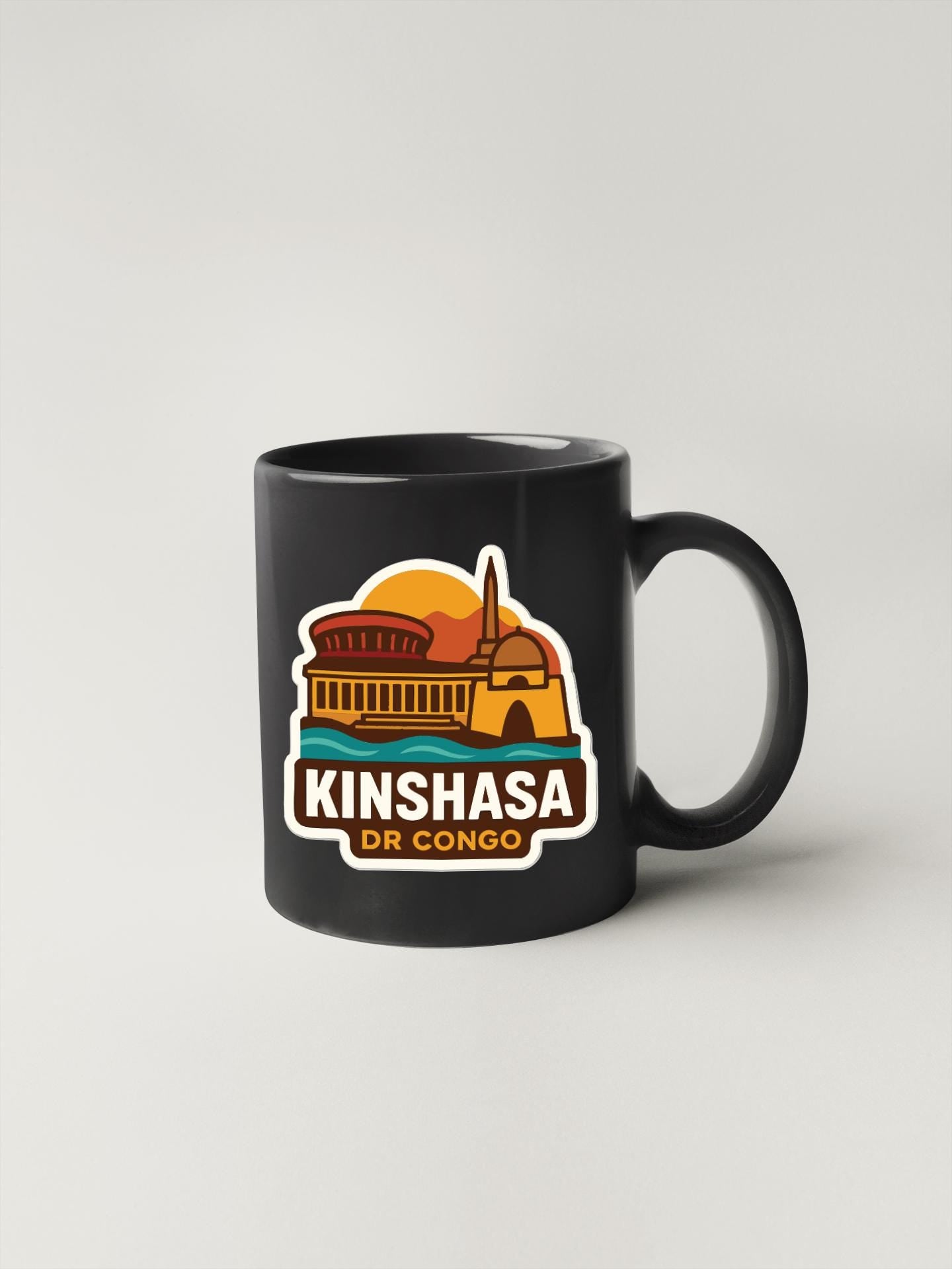 A black coffee mug with a colorful sticker depicting a building and the text "KINSHAZA DR CONGO".