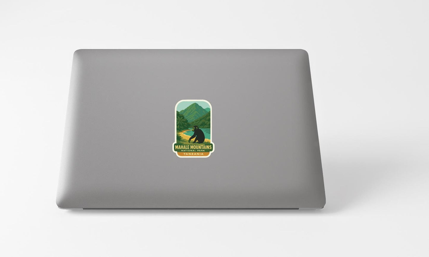 A sticker with a mountain landscape and a bear on it is placed on the back of a laptop computer.
