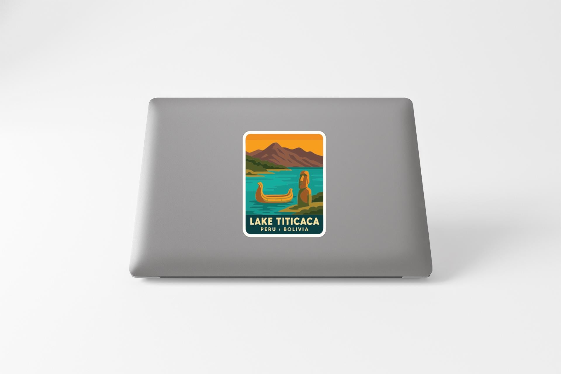 A sticker on the back of a laptop, depicting a scenic landscape with mountains, a lake, and a canoe.