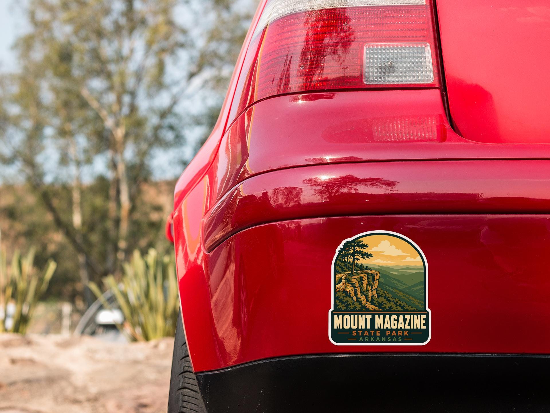 the rear end of a red car with a sticker on the trunk that says "Mount Magazine Arkansas".