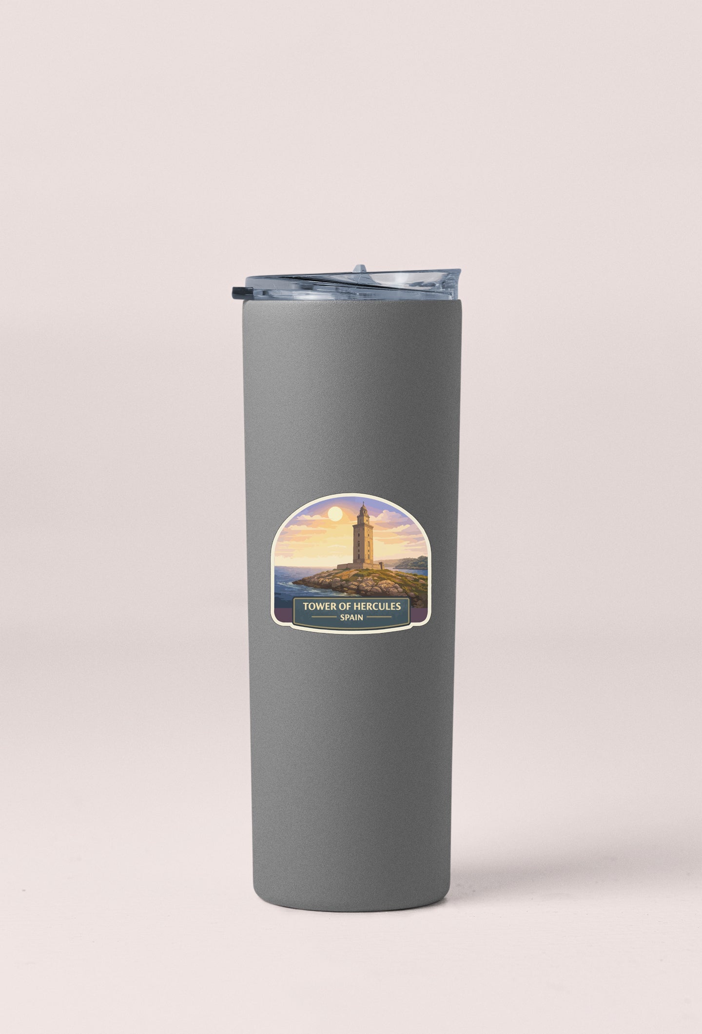 A gray cylindrical thermos with a label featuring the image of the Tower of Hercules in Herculaneum, Spain.