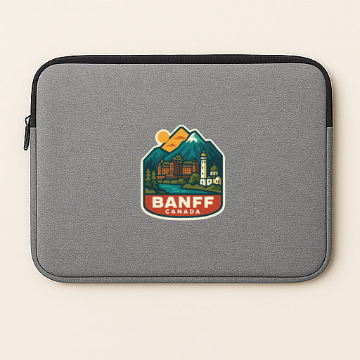 A gray laptop sleeve with a colorful logo of Banff, Canada, featuring a mountain landscape and a lighthouse.