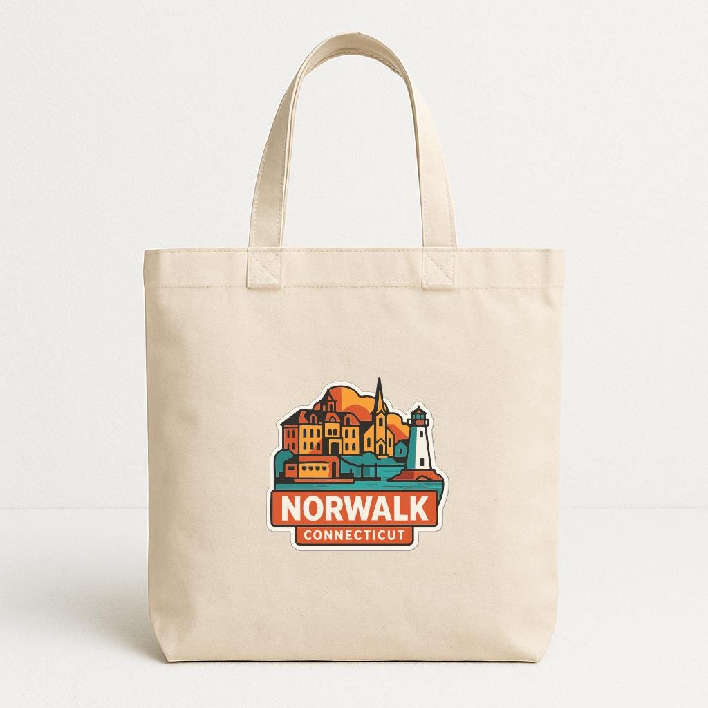 A beige tote bag with a colorful graphic of a town and a lighthouse, along with the text "NORWALK CONNECTICUT".