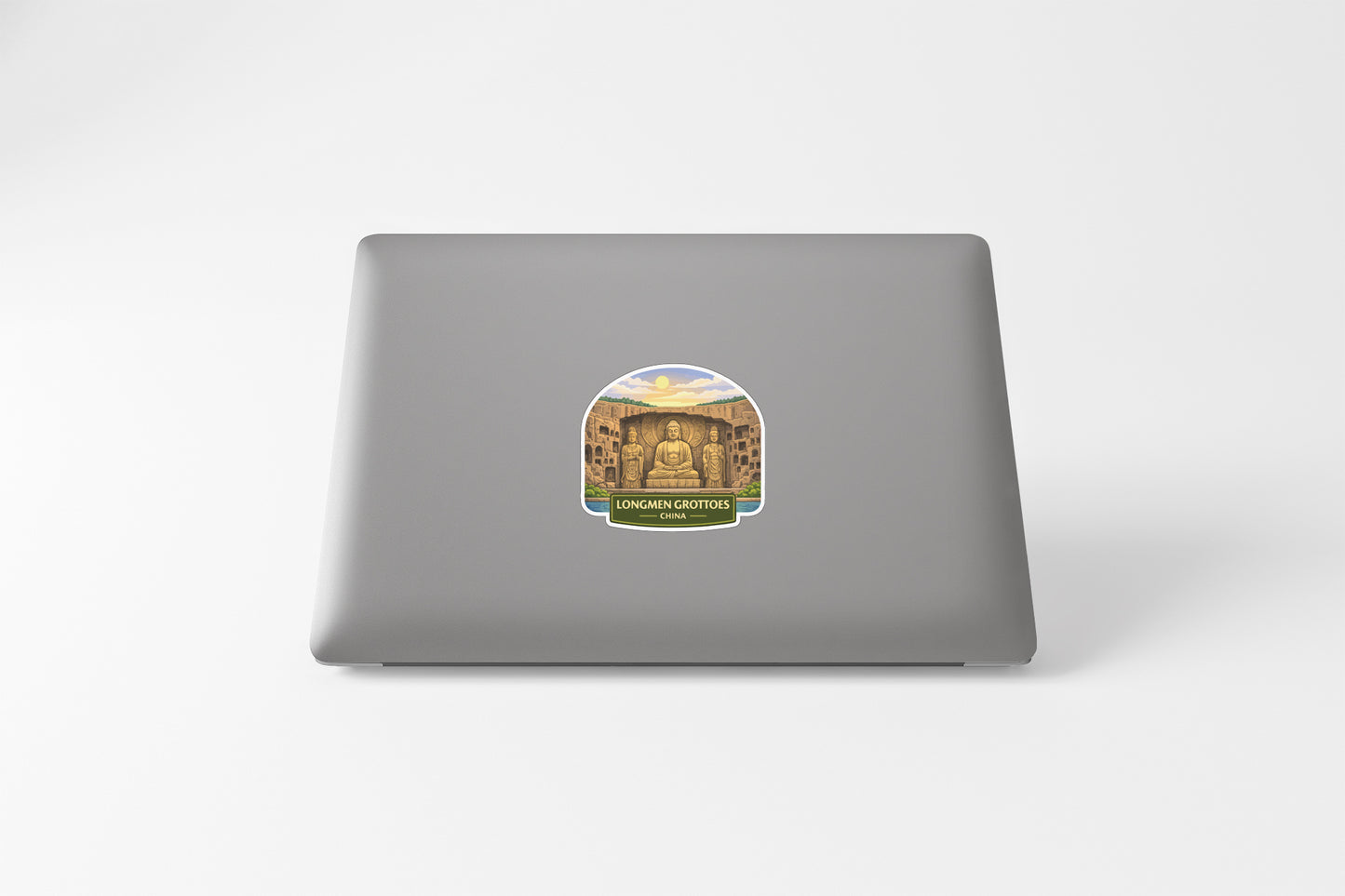a sticker with an illustration of a temple or monument, placed on the back of a laptop computer.