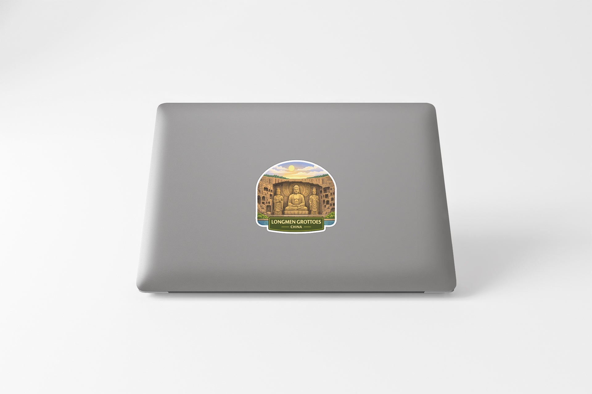 a sticker with an illustration of a temple or monument, placed on the back of a laptop computer.