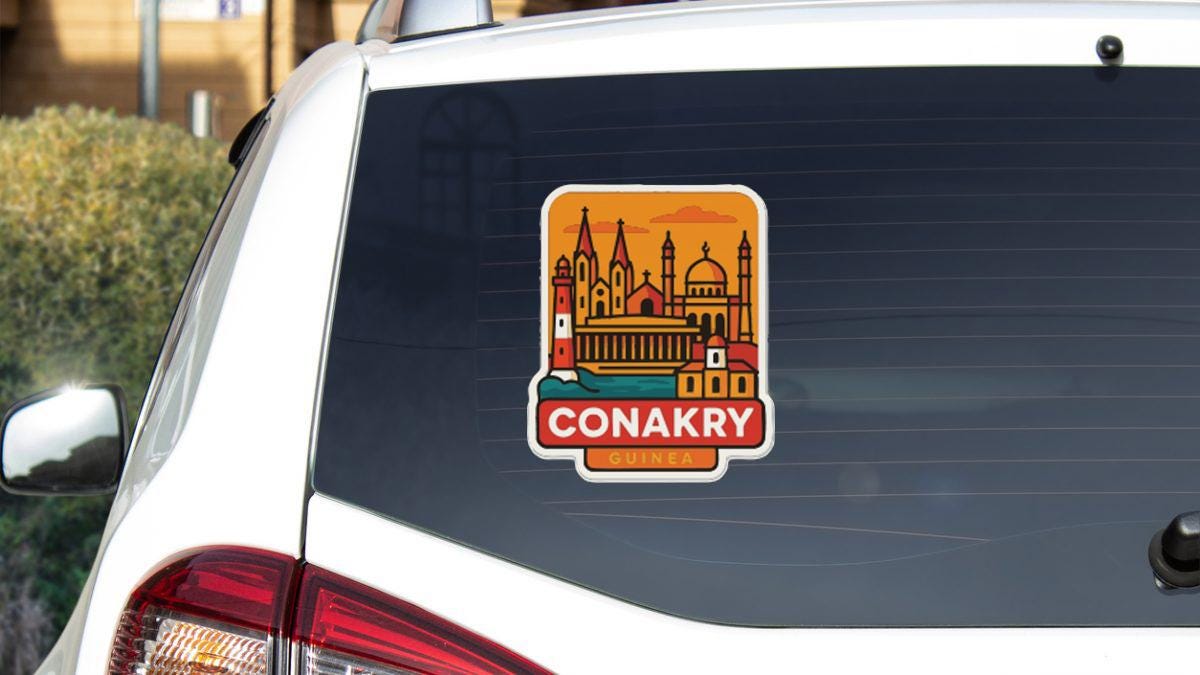 A sticker on the rear window of a car, depicting the cityscape of Conakry, Romania.