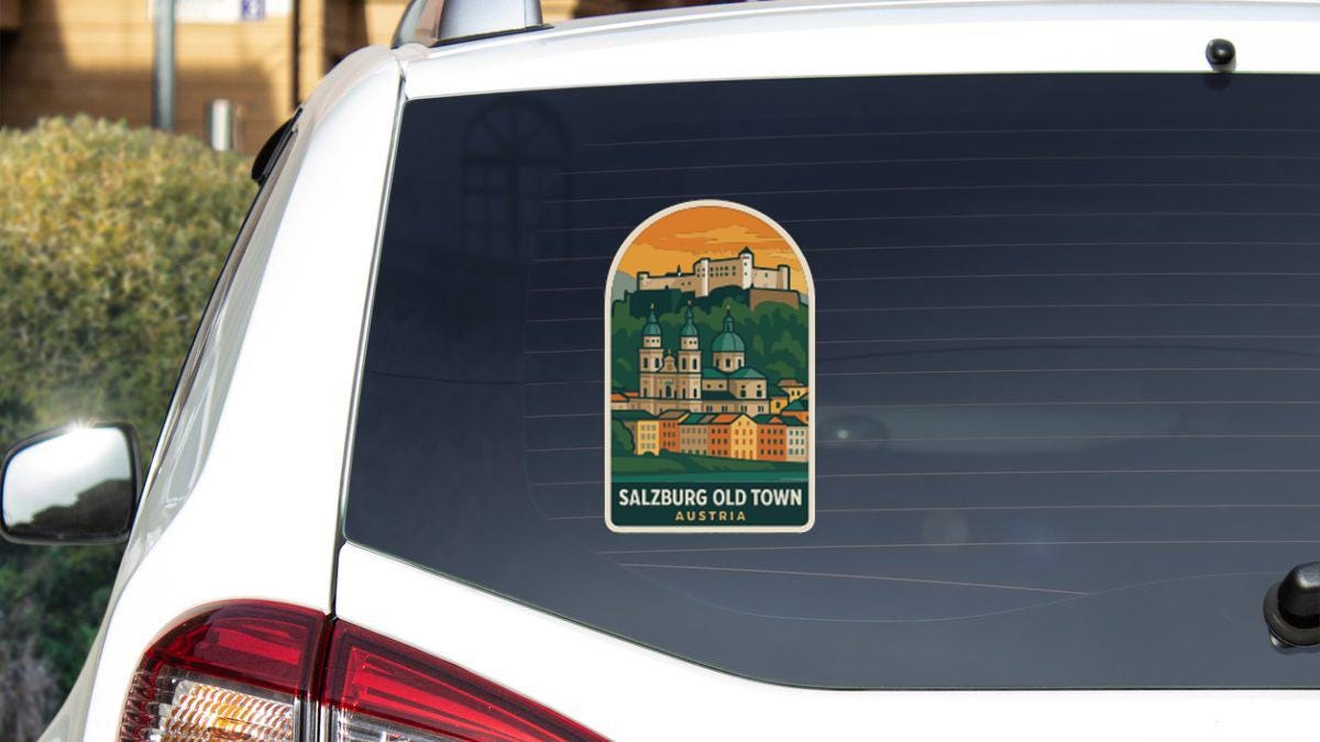 a sticker on the rear window of a car, depicting a cityscape with a castle or palace in the background.