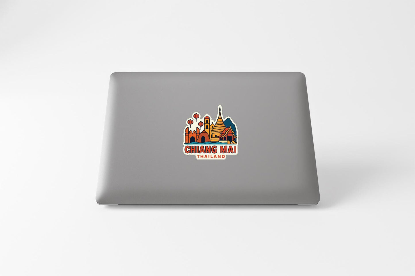 a sticker with a colorful illustration of a temple and the text "CHIANG MAI THAILAND" on the back of a laptop.