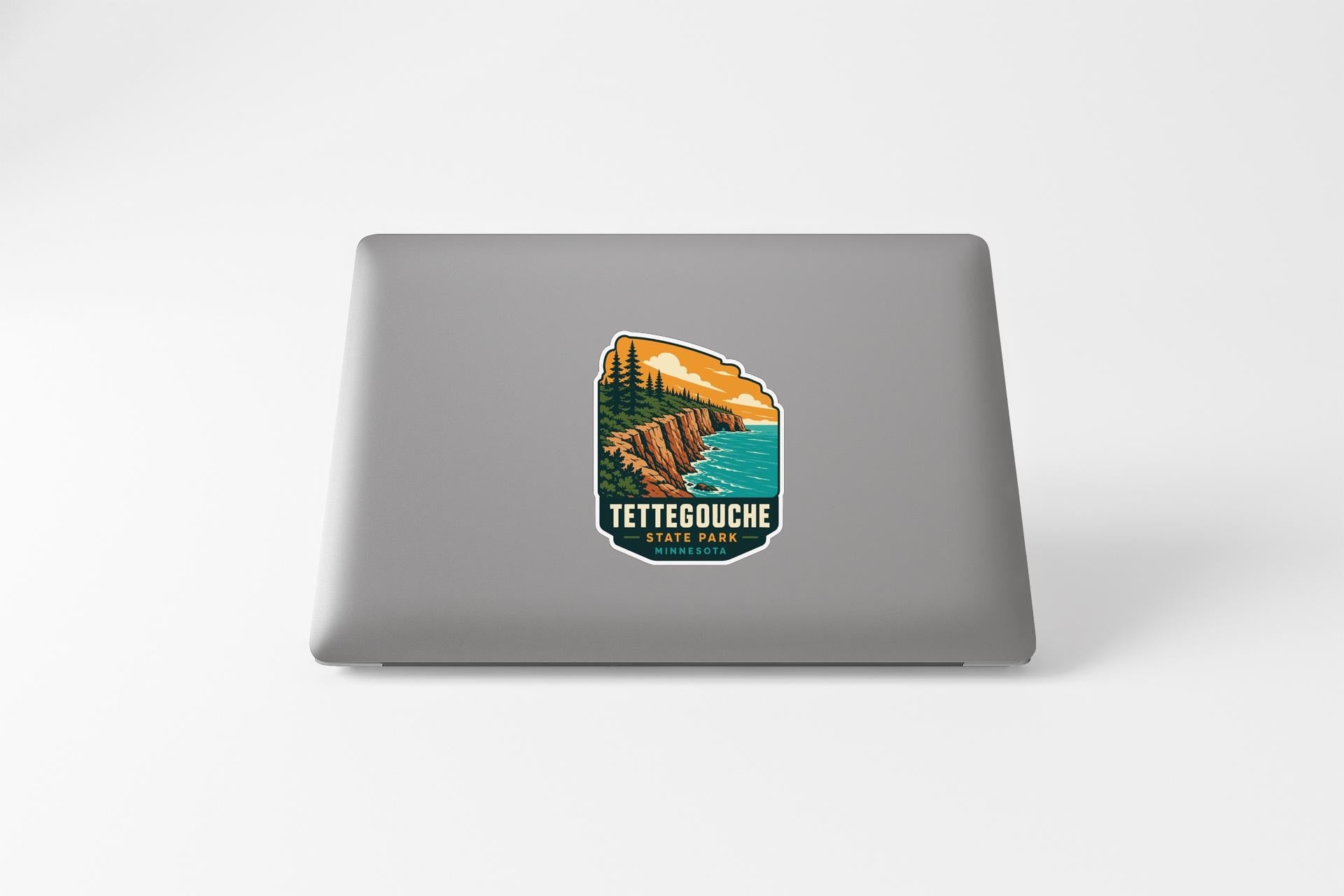 A sticker featuring a scenic landscape with a mountain, trees, and a body of water, along with the text "TETTEGOUCHE STATE PARK".