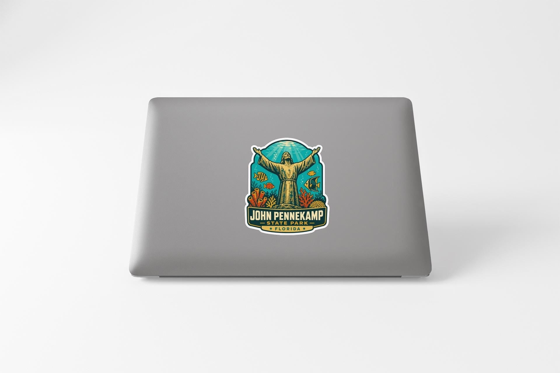 A sticker on the back of a laptop, featuring an illustration of a person with outstretched arms and the text "JOHN PENNECAMP" and "ST. LOUIS, MO."