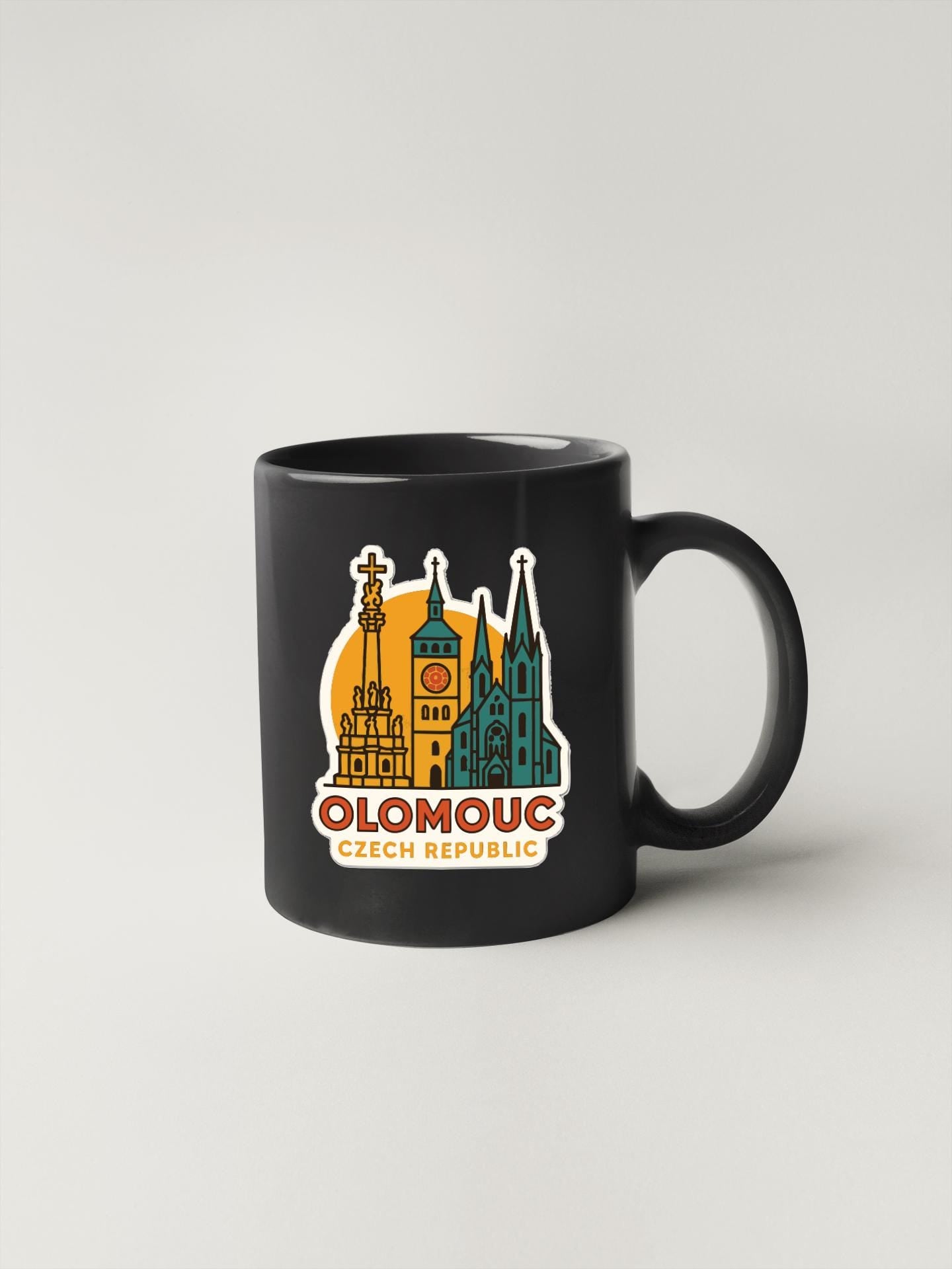 A black coffee mug with a graphic design featuring the cityscape of Olomouc, Czech Republic.