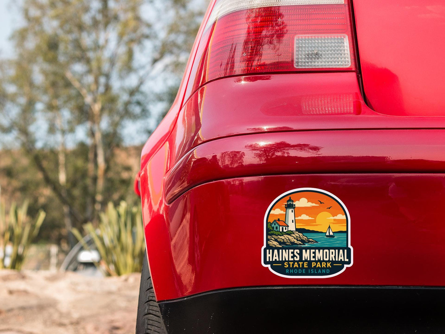 the rear end of a red car with a sticker on the trunk that says "HAINES MEMORIAL STATE PARK RIDGE DEWAL".