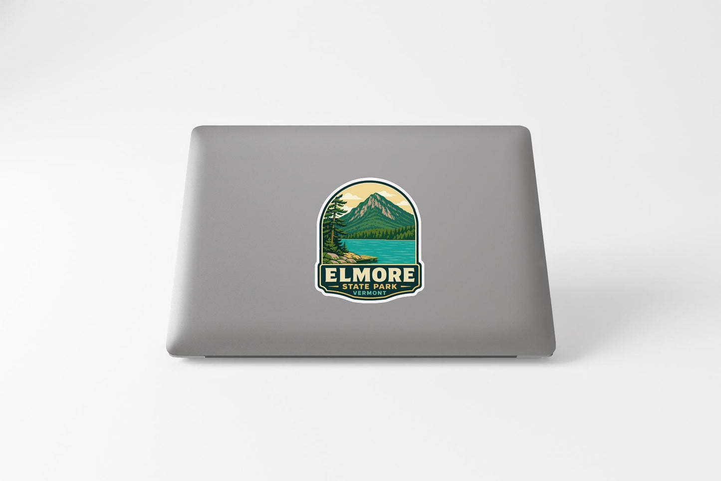 A sticker on the back of a laptop displaying a mountain landscape with a lake.