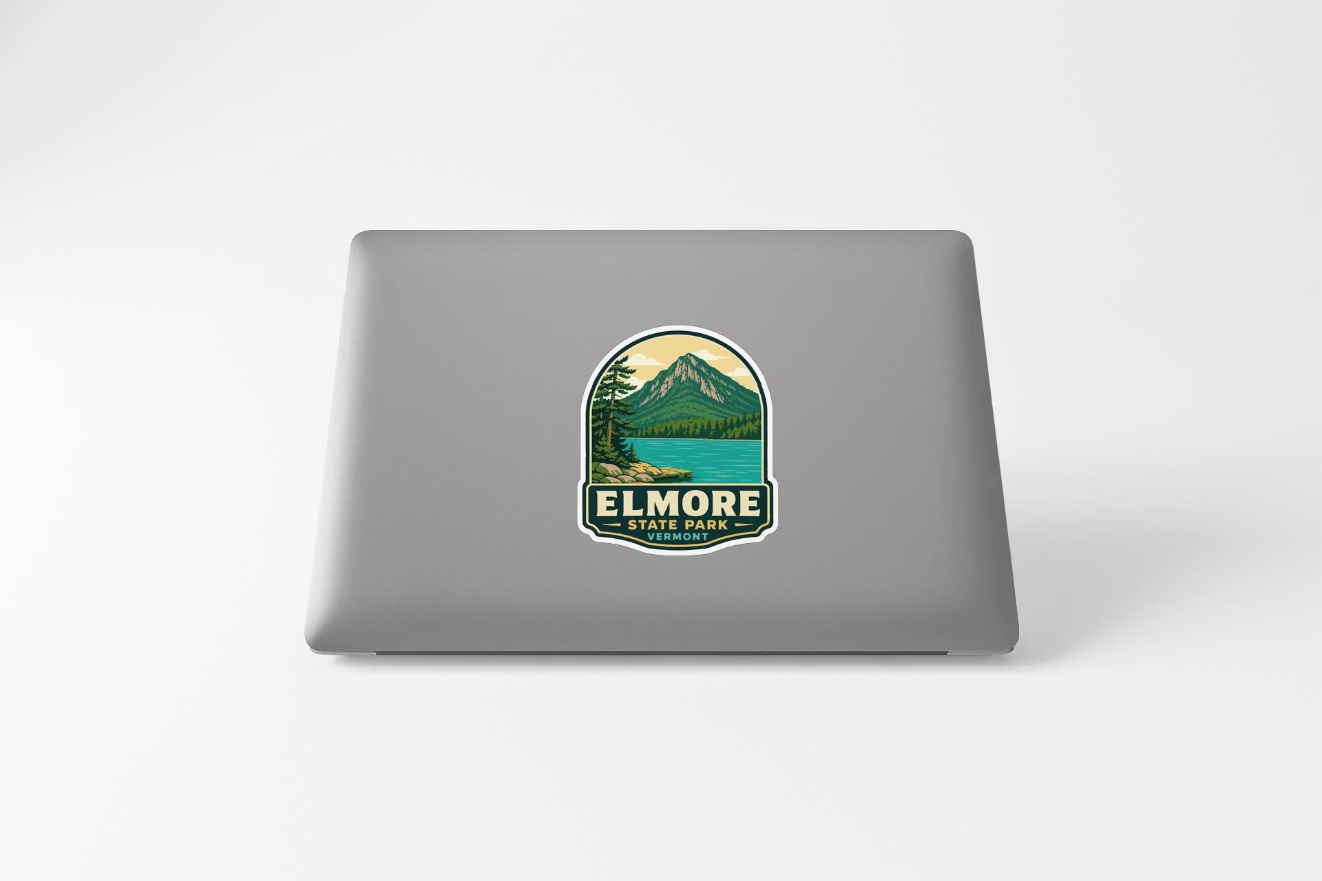 A sticker on the back of a laptop displaying a mountain landscape with a lake.