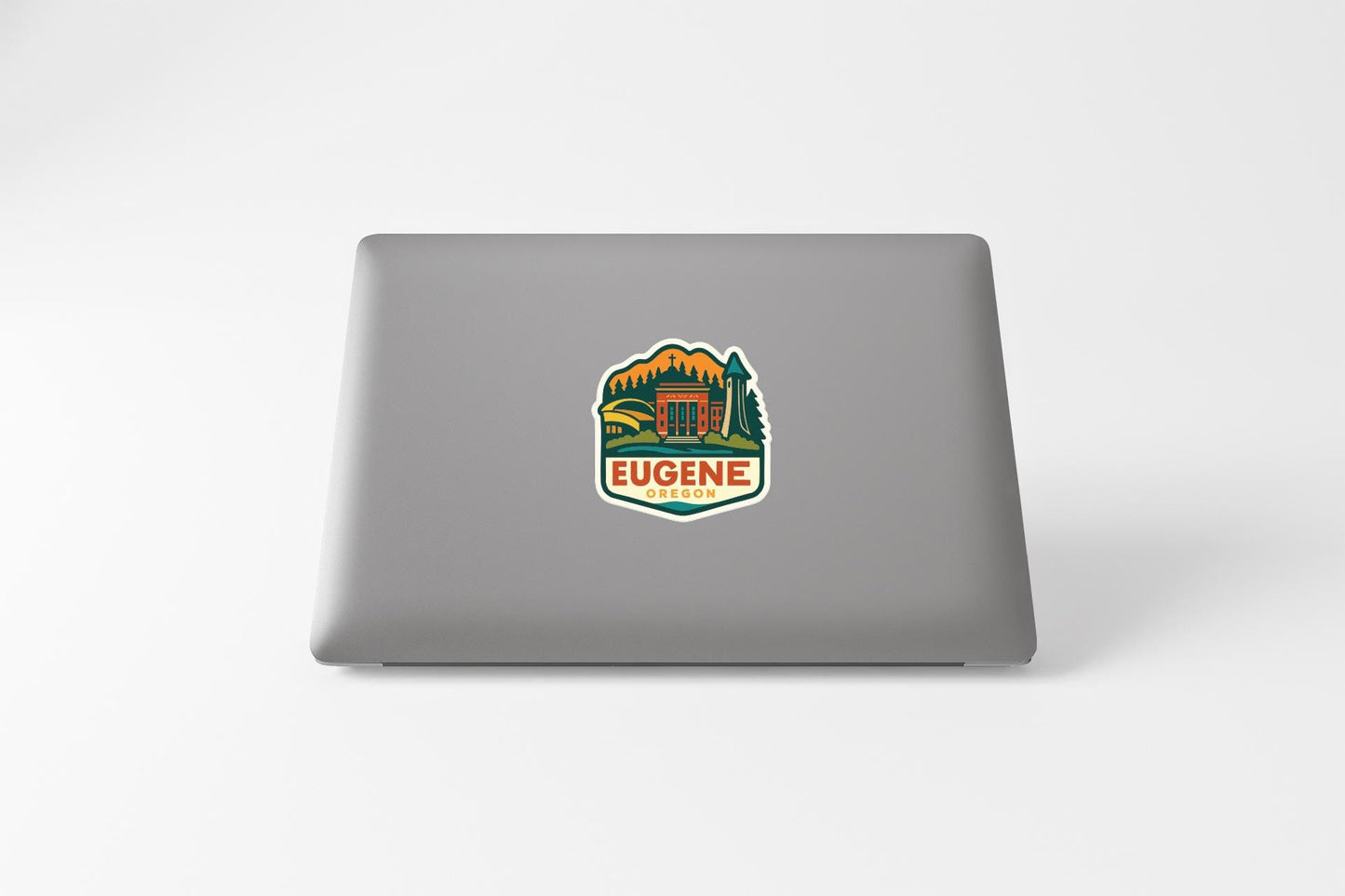 a sticker with a logo of a mountain and a building, placed on the back of a laptop computer.