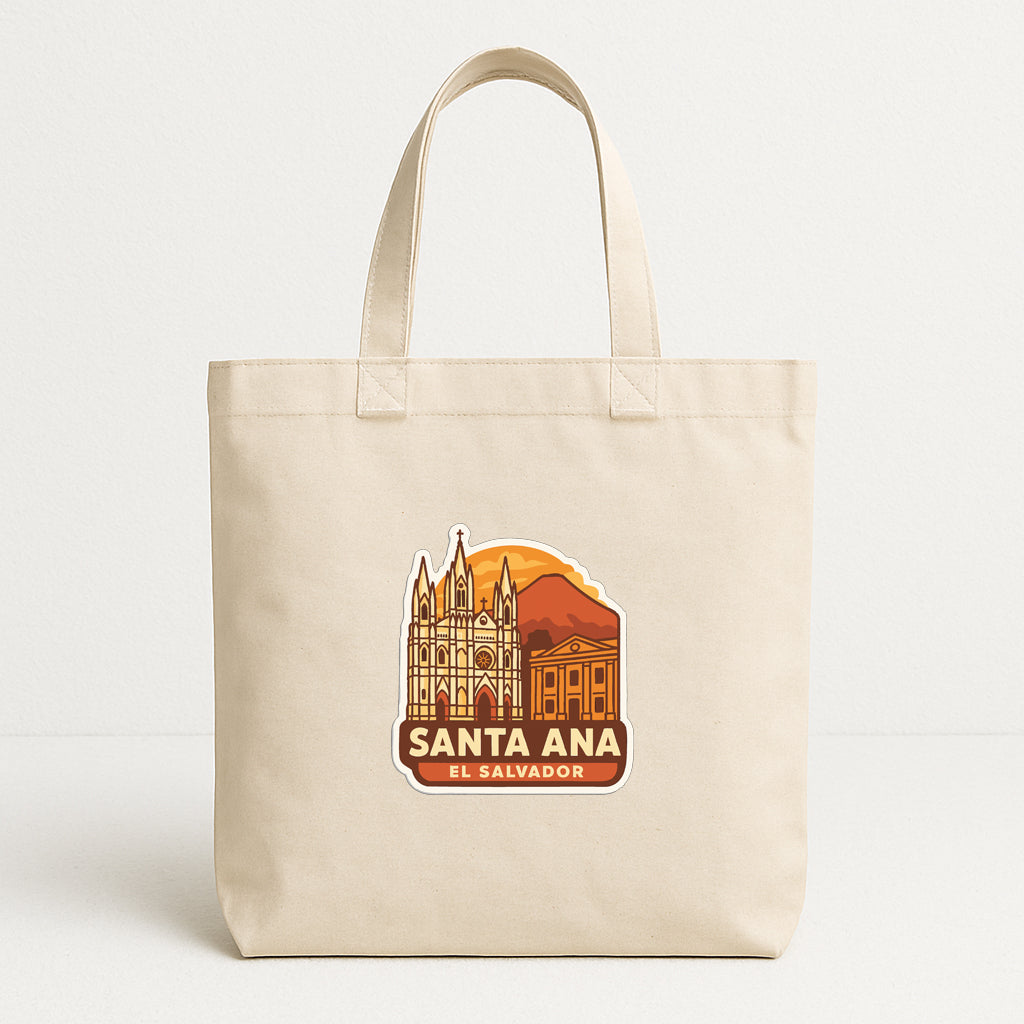 A beige tote bag with a printed design featuring a city skyline and the text "SANTA Ana EL SALVADOR".