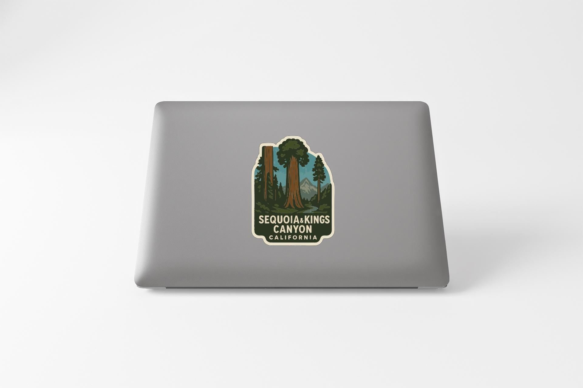 a sticker with a graphic of a tree and the text "SEQUOIA KINGS CANYON CALIFORNIA" printed on a laptop.