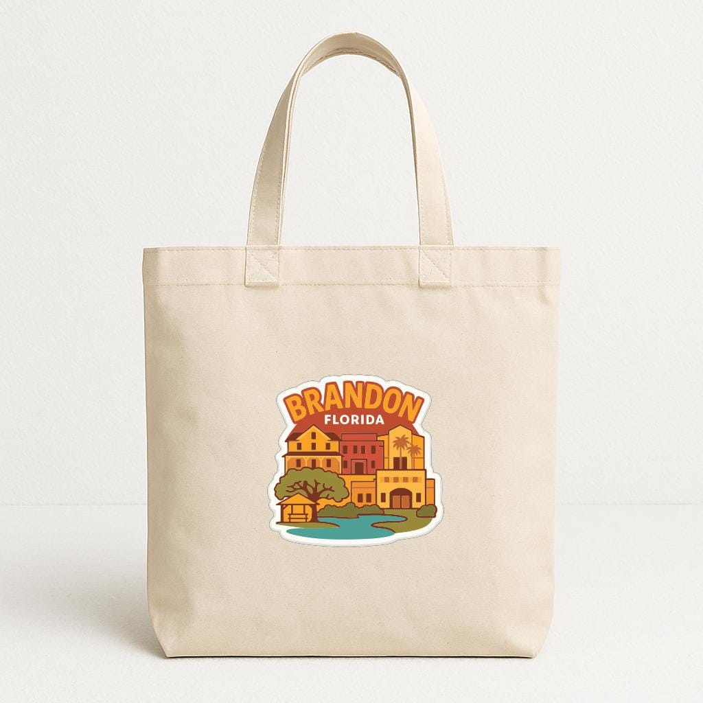 A beige tote bag with a printed design depicting a cityscape and the text "BRANDON FLORIDA" printed on it.