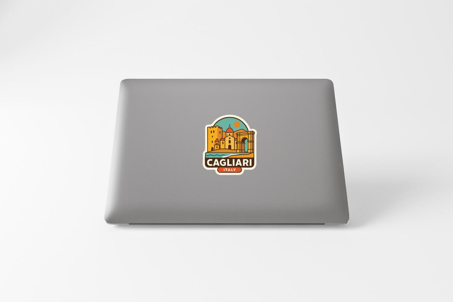 a sticker with a cityscape and the text "Cagliari ITALY" on the back of a laptop.