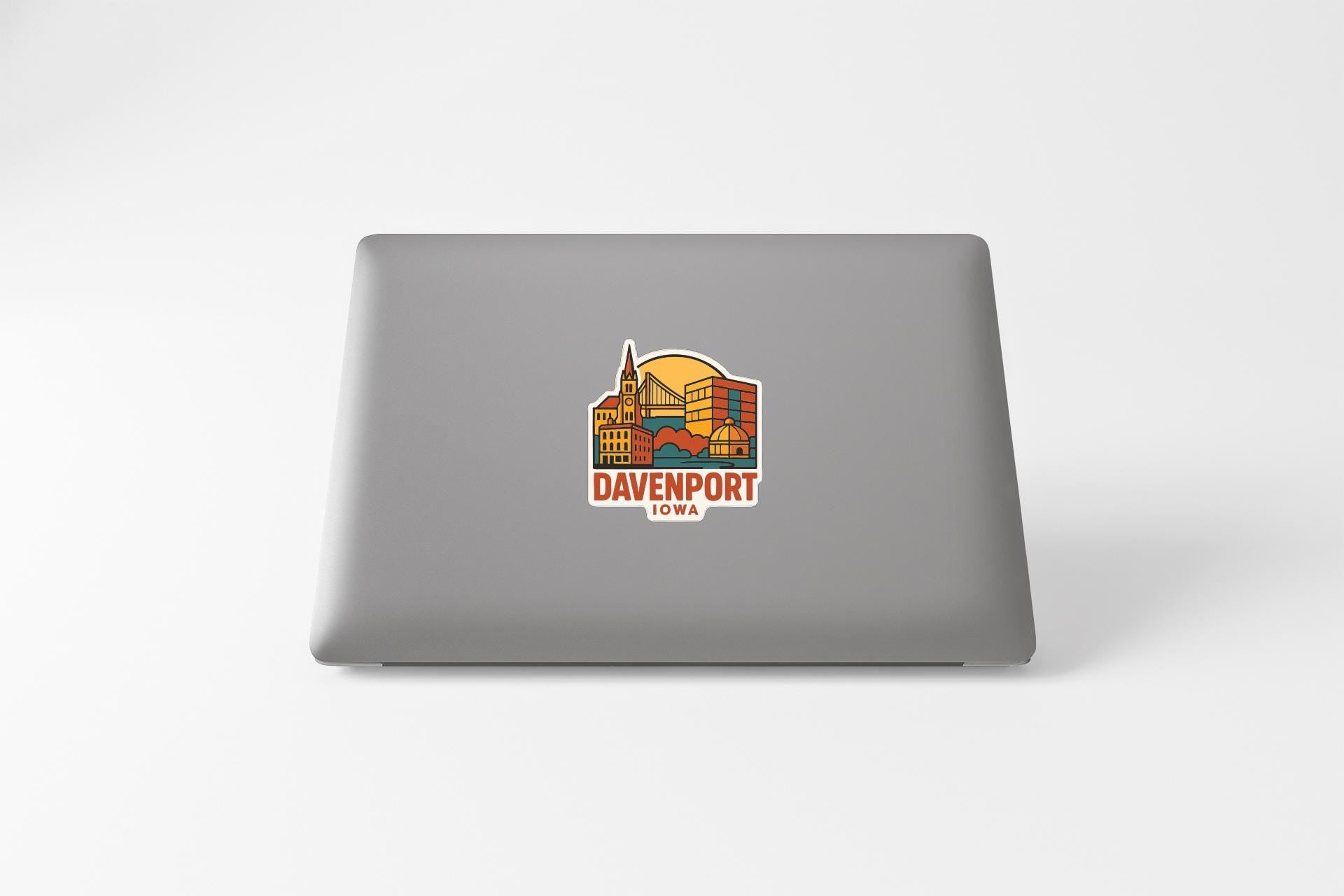 a sticker with a colorful illustration of a cityscape and the text "DAVENPORT IOWA" on the back of a laptop.