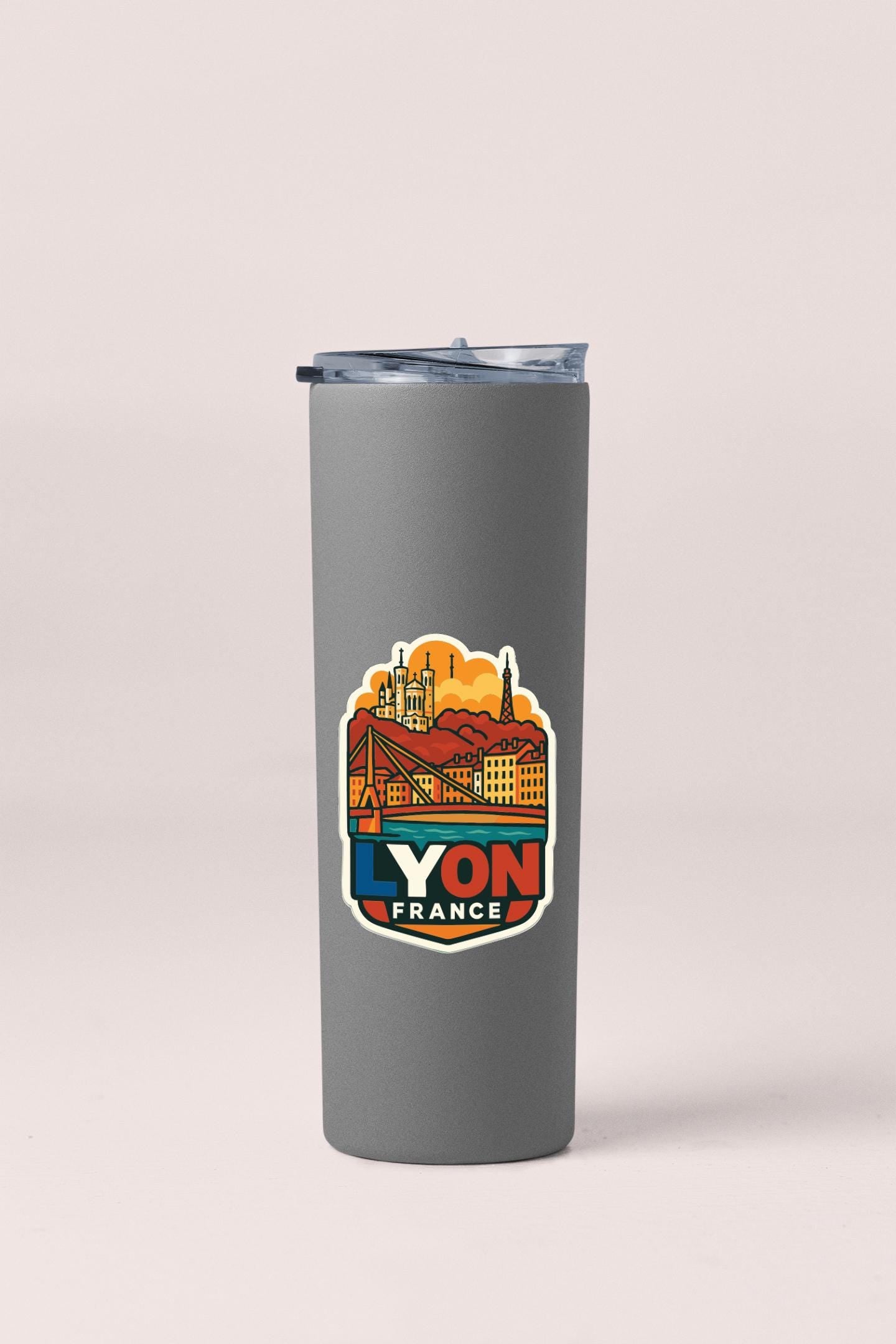 A gray insulated tumbler with a sticker depicting the city of Lyon, France.
