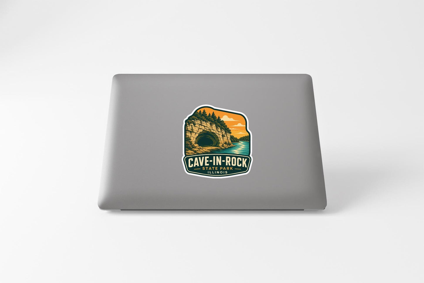 a sticker on a laptop that says "CAVE-IN-ROCK" and "WILDCATS PARK", along with a scenic illustration of a cave and a sunset.