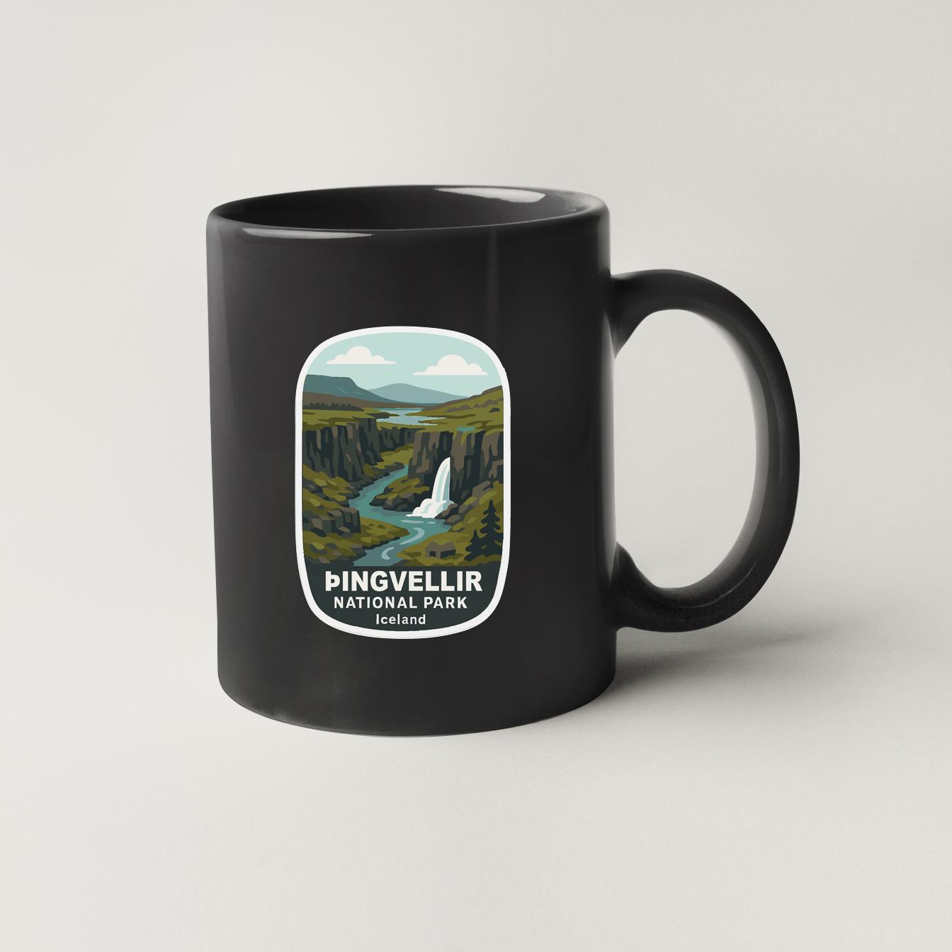 A black coffee mug with a graphic design depicting a scenic landscape featuring a waterfall and mountains.