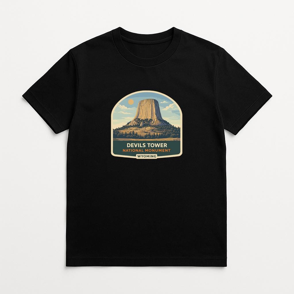 A black t-shirt with a graphic design depicting the Devils Tower, a famous landmark in Yellowstone National Park.