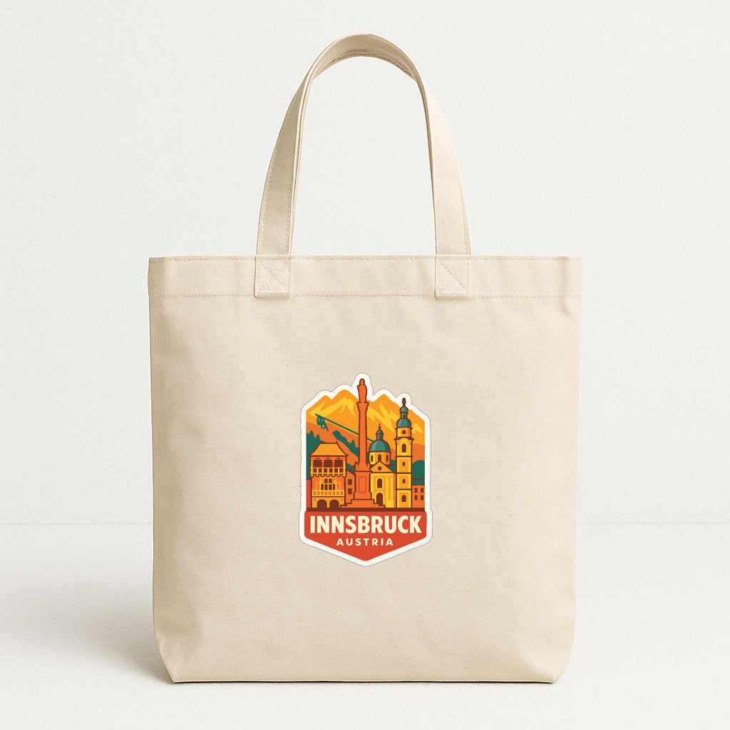 A beige tote bag with a graphic design featuring a cityscape and the text "INNSBRUCK AUSTRIA" printed on it.