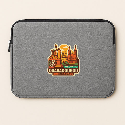 A gray laptop sleeve with a sticker depicting the city of Quagadougou, Burkina Faso.