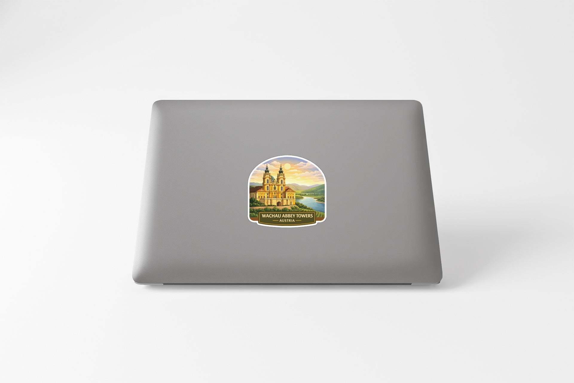 A sticker depicting a building with a castle-like structure, likely representing Waczębmy Towers, is placed on the back of a laptop.