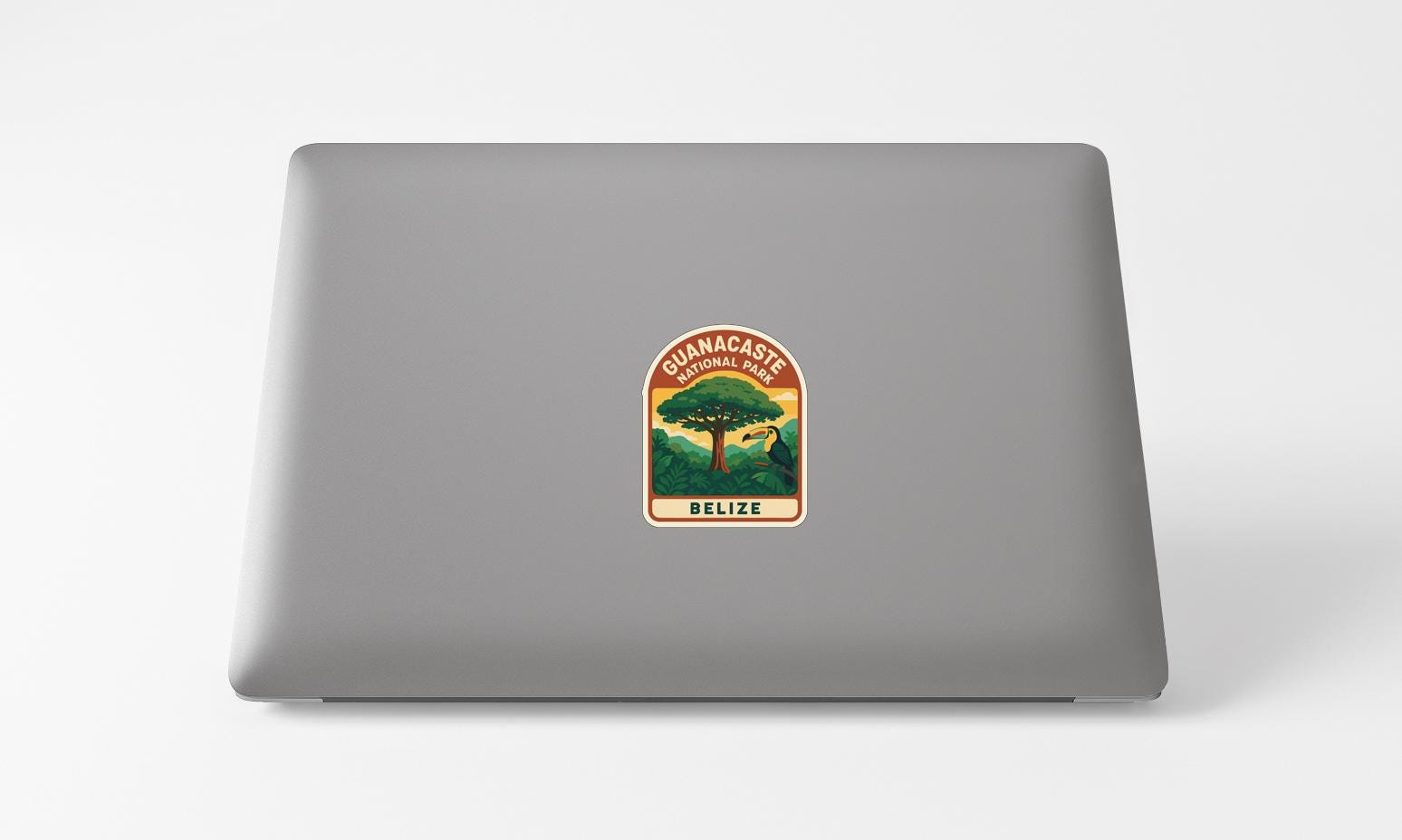 A sticker on the back of a laptop, depicting a tropical landscape with a tree and the text "GUANACASTE NATIONAL PARK BELIZE".