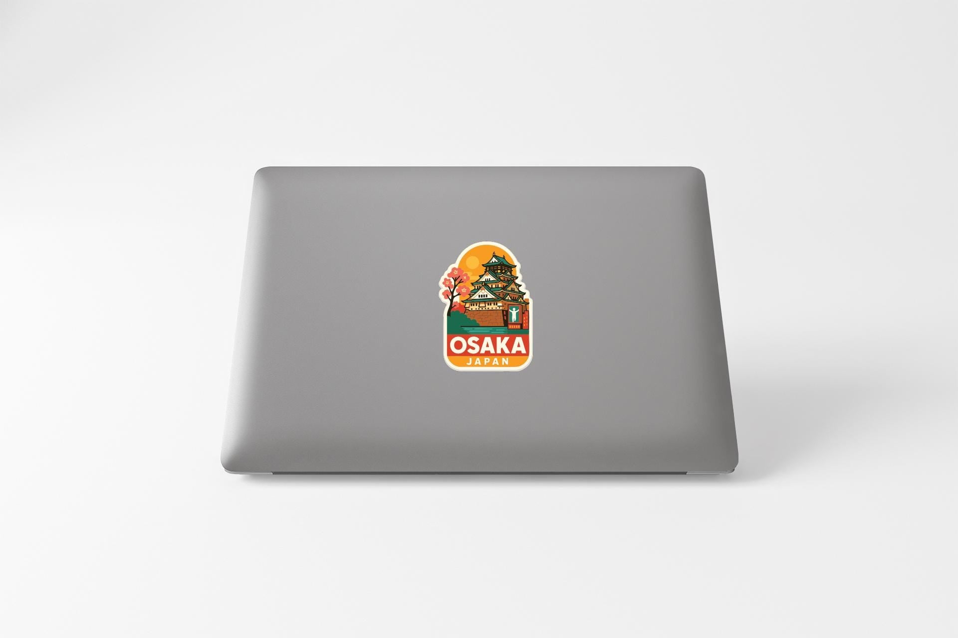 A sticker on the back of a laptop displaying the name 'OSAKA JAPAN'.