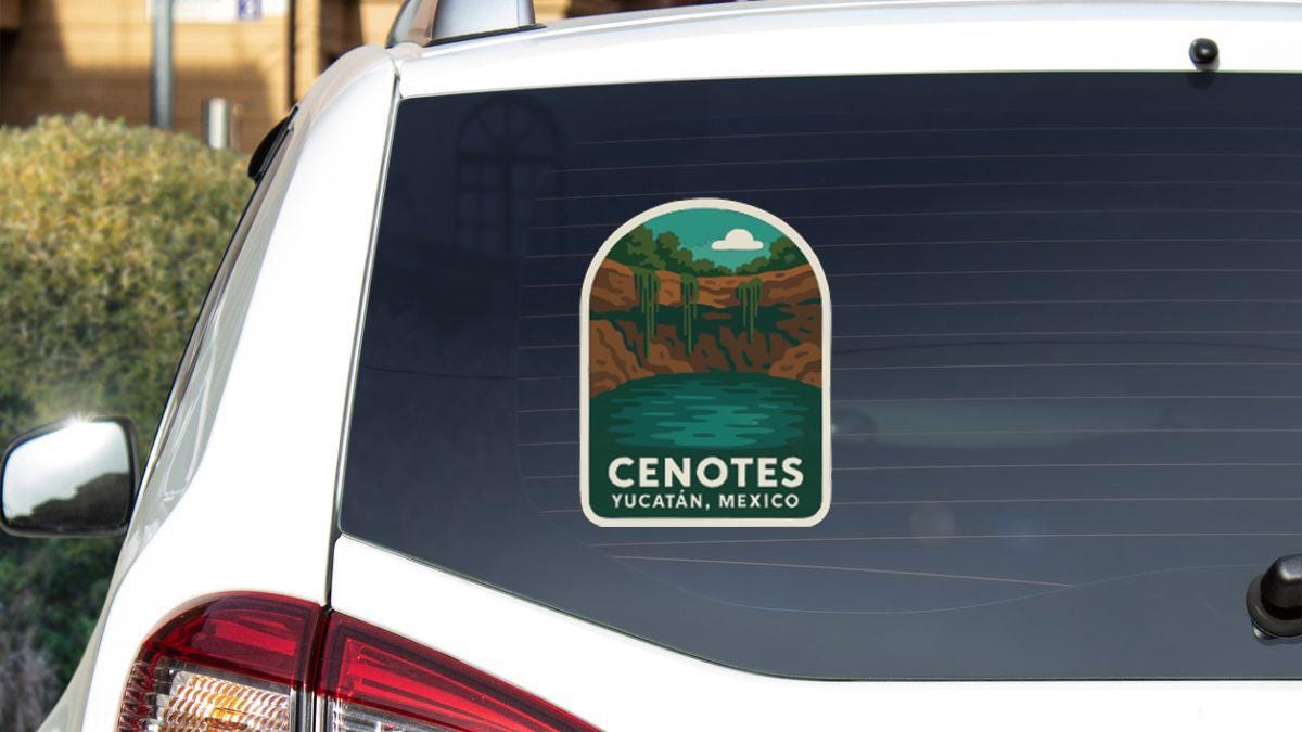 A sticker on the rear window of a white car, depicting a scenic landscape with a lake and mountains.