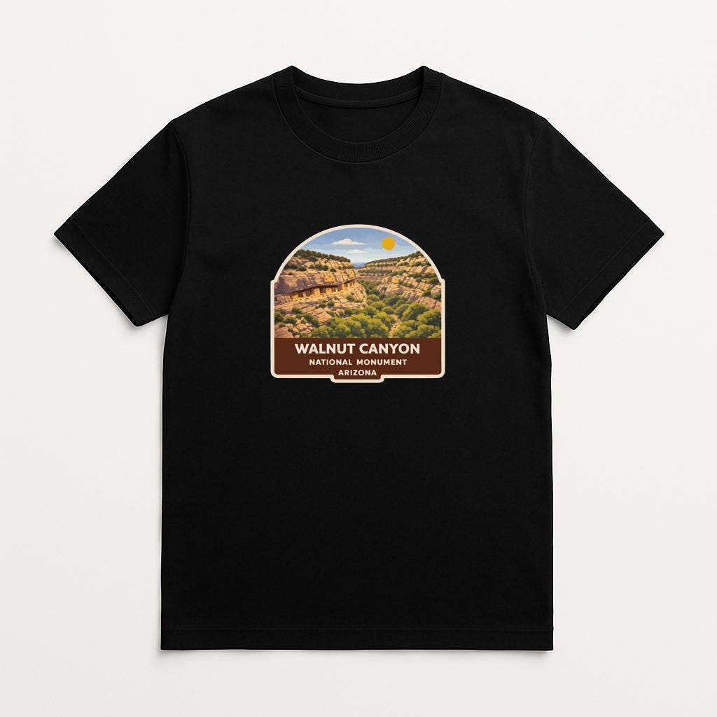 A black t-shirt with a graphic design depicting the scenic landscape of Walnut Canyon National Monument in Arizona.