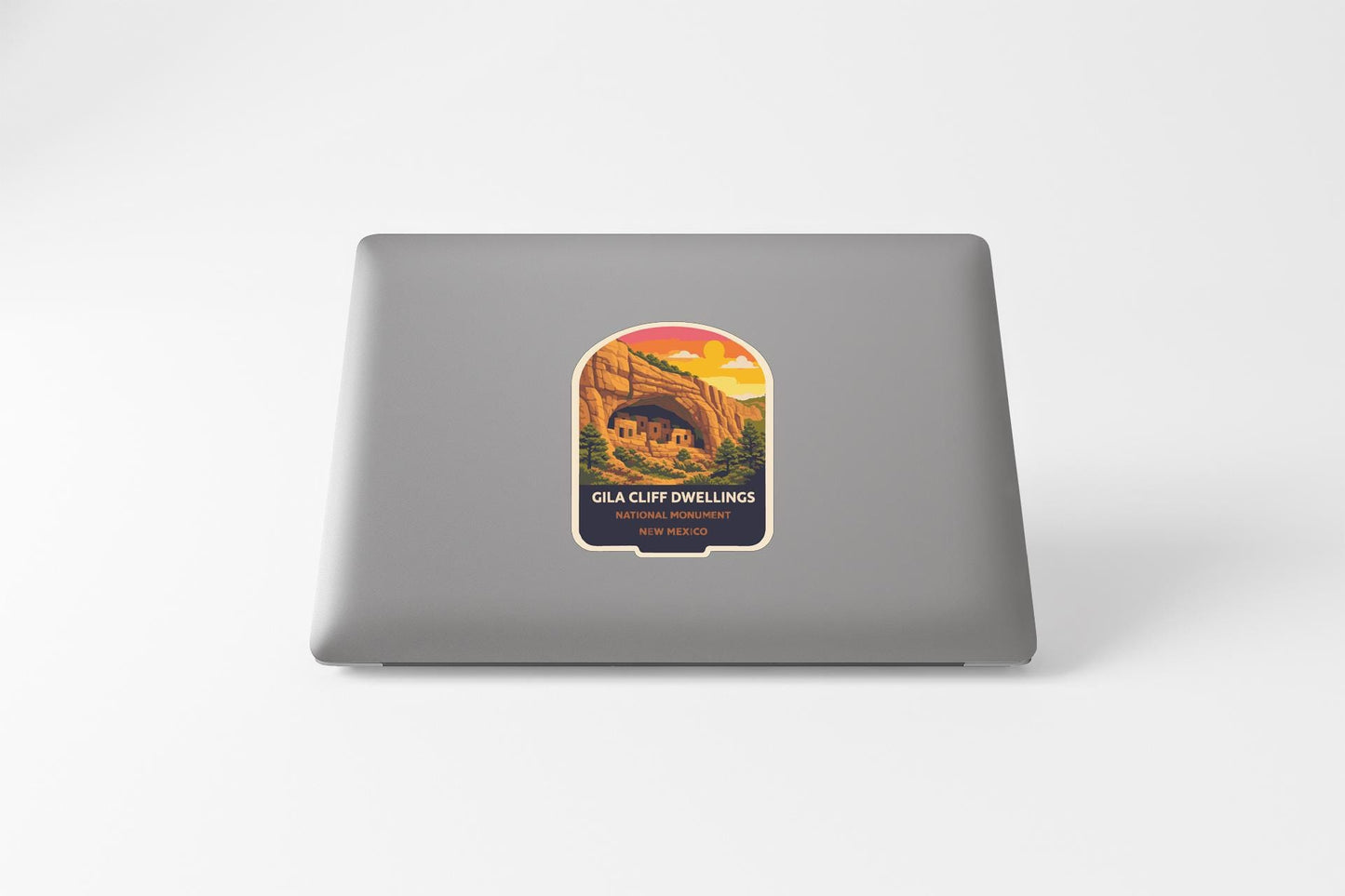 a sticker on the back of a laptop with a mountain landscape and a house.