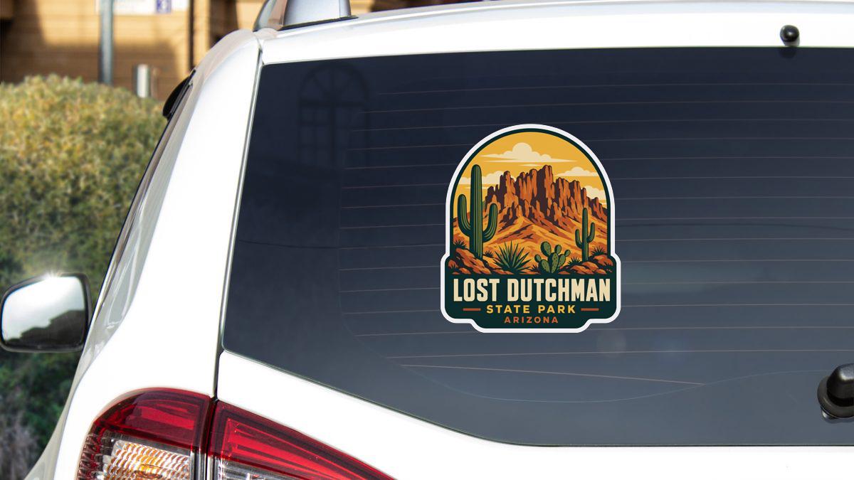 A sticker on the rear window of a white vehicle, depicting a desert landscape with mountains and cacti.