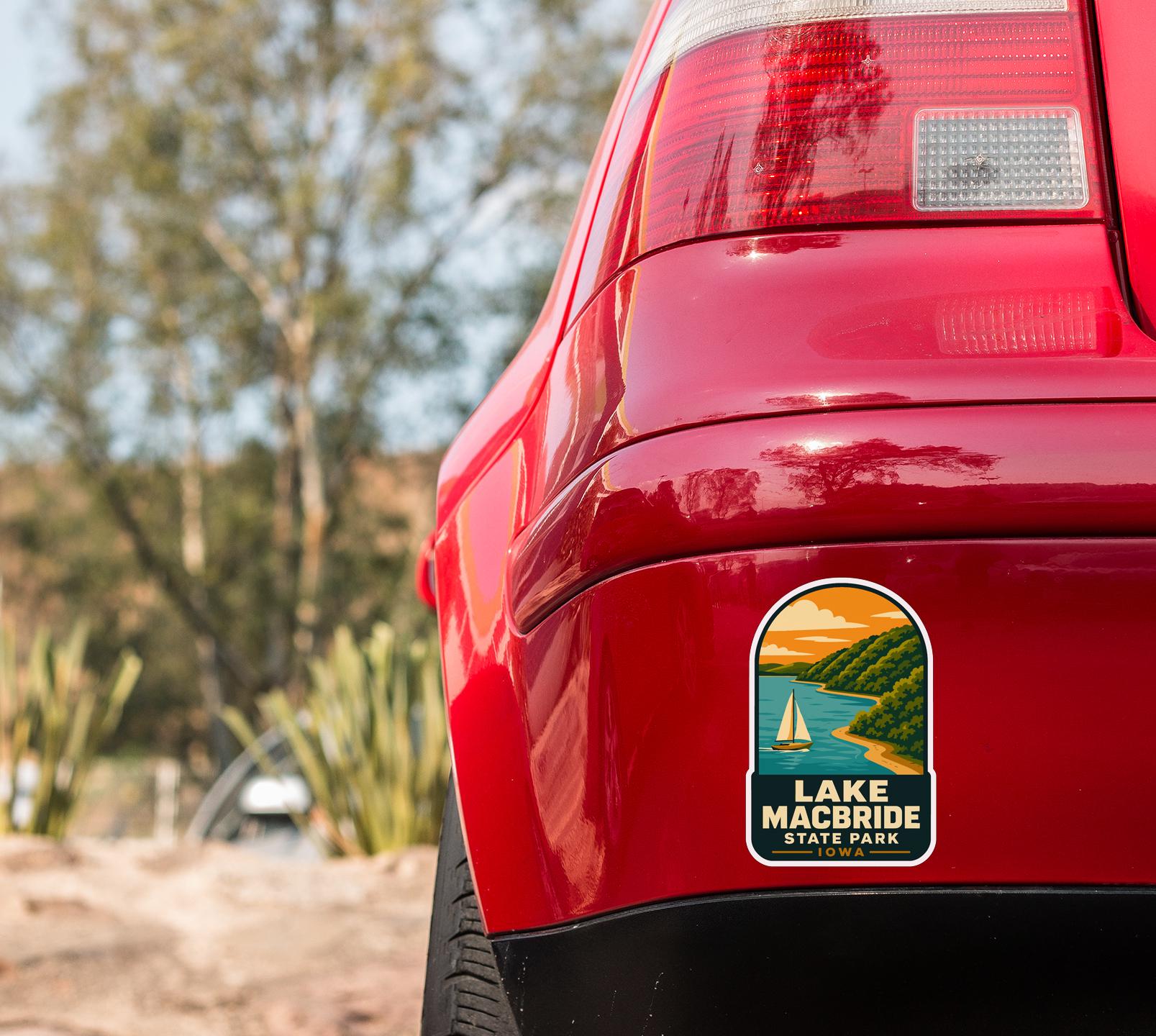 the rear end of a red car with a sticker on the back window that says "Lake Macbride State Park".