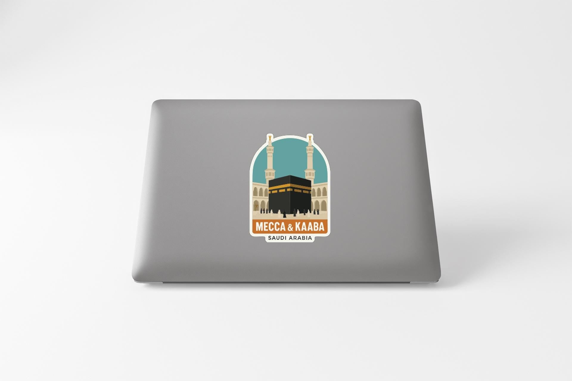 a sticker or decal on the back of a laptop, depicting a mosque with two minarets and a black building in the center.