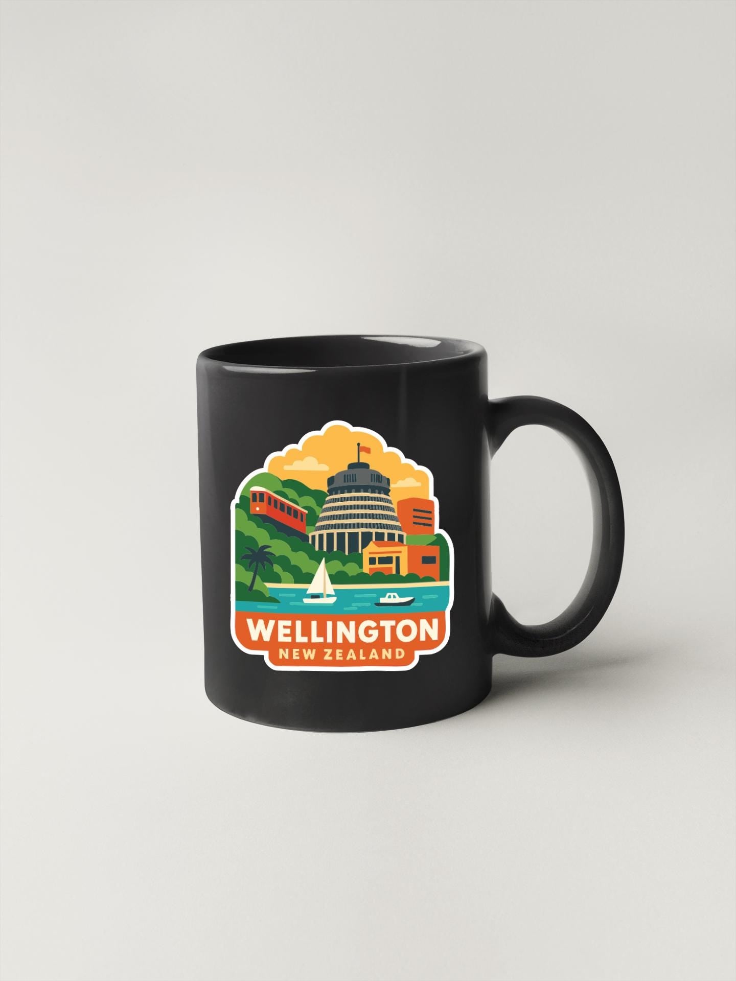 A black coffee mug with a colorful illustration of the Wellington, New Zealand capital, depicting a cityscape with a castle, a harbor, and a sailboat.