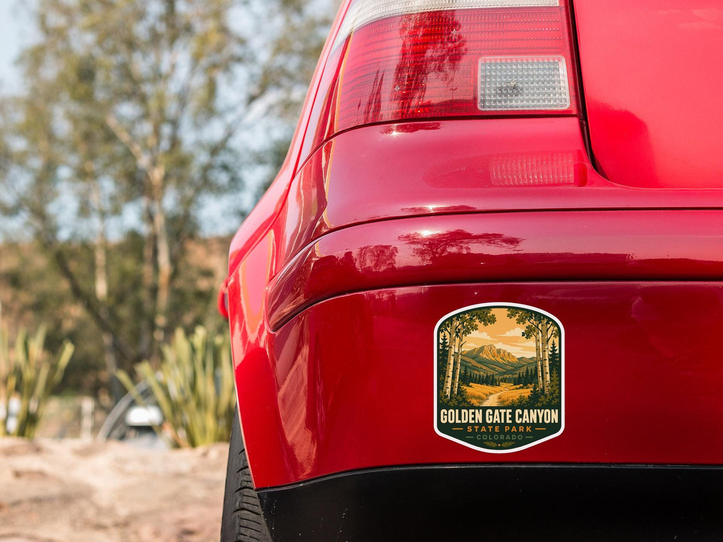 the rear end of a red car with a sticker on the back window that reads "Golden Gate Canyon State Park".