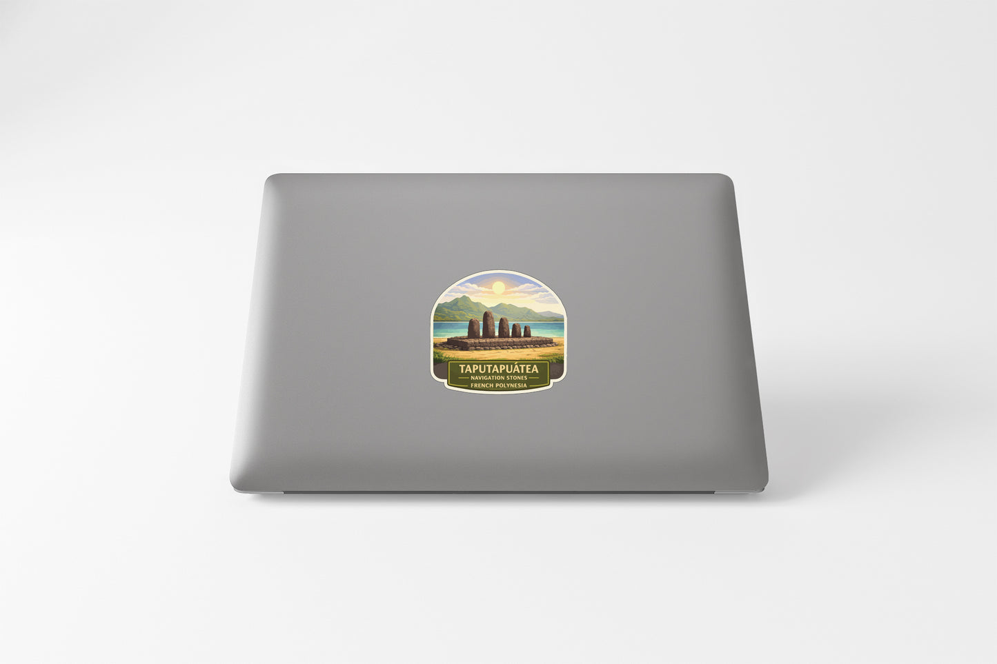 a sticker on the back of a laptop, depicting a scenic landscape with mountains and a body of water.