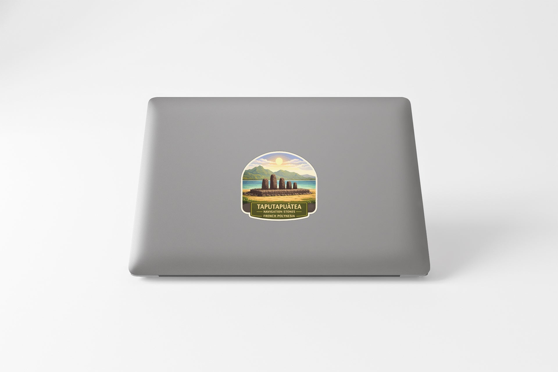 a sticker on the back of a laptop, depicting a scenic landscape with mountains and a body of water.