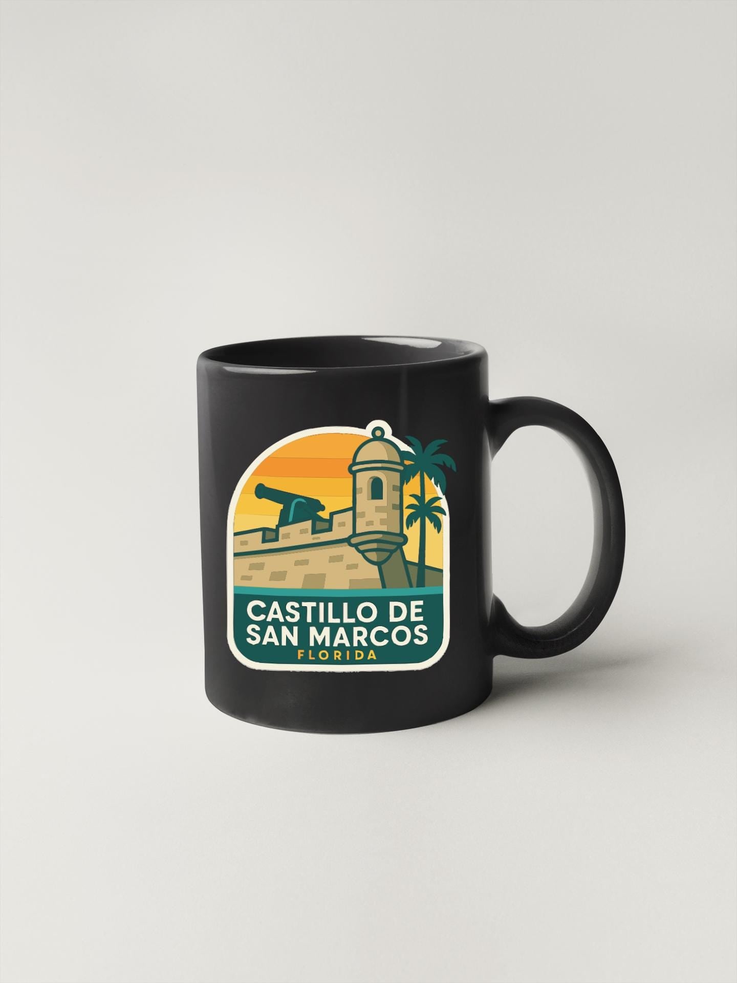 A black coffee mug with a graphic design depicting the Castillo de San Marcos, a historic fortification in Florida.